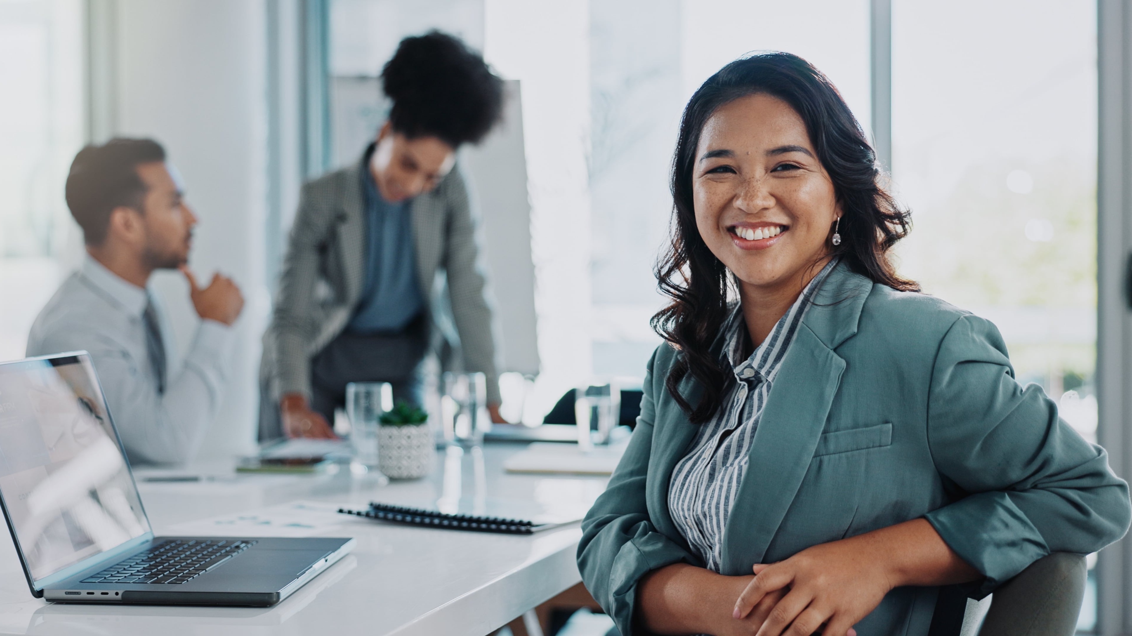 Woman with a laptop smiling during a meeting